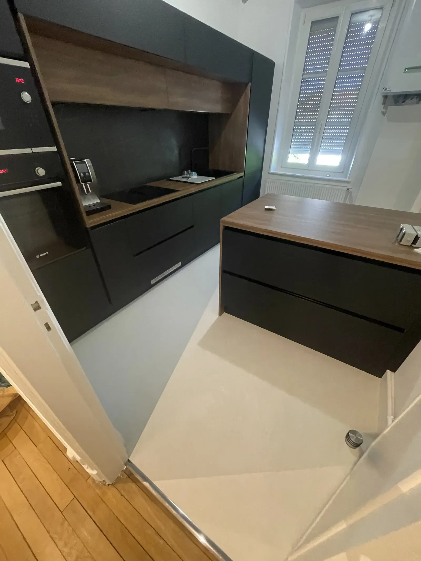Cuisine contemporaine noire avec plan de travail en bois